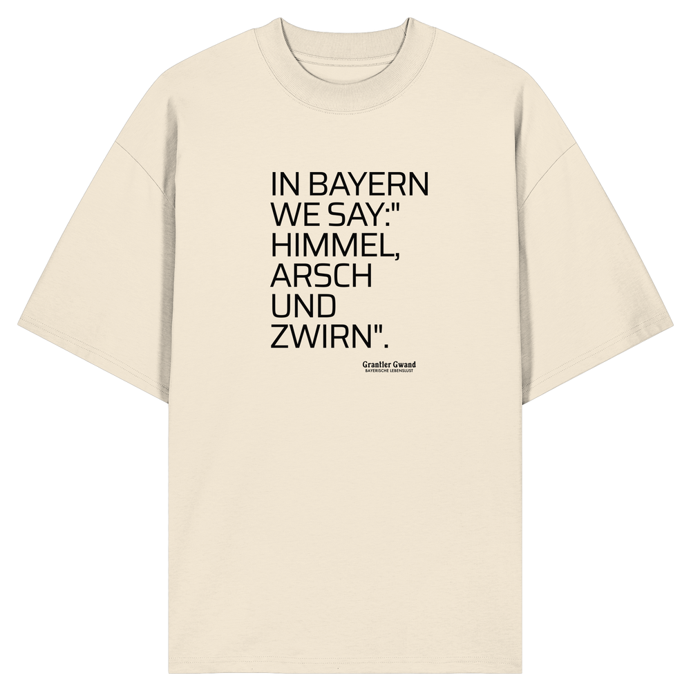 Naturfarbenes  Oversize Shirt mit schwarzem Schriftzug „In Bayern we say: Himmel, Arsch und Zwirn“ auf der Vorderseite von Grantler Gwand.