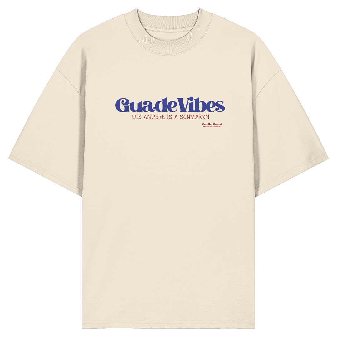 Cremefarbenes Oversize Bio-Shirt mit blauem Frontprint „Guade Vibes – Ois andere is a Schmarrn“ – bayerisches Streetwear Shirt mit modernem Dialekt-Spruch von Grantler Gwand.