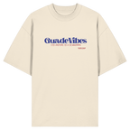 Cremefarbenes Oversize Bio-Shirt mit blauem Frontprint „Guade Vibes – Ois andere is a Schmarrn“ – bayerisches Streetwear Shirt mit modernem Dialekt-Spruch von Grantler Gwand.