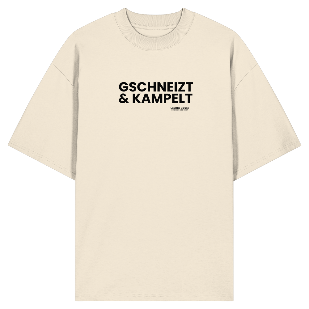 Beiges Oversize-T-Shirt mit schwarzem Frontprint „Gschneizt & Kampelt“. Modernes Unisex-Shirt mit bayerischem Dialekt im minimalistischen Streetwear-Design für Volksfest, Biergarten und Alltag. Hochwertige Bio-Baumwolle, designed und bedruckt in Bayern von Grantler Gwand.