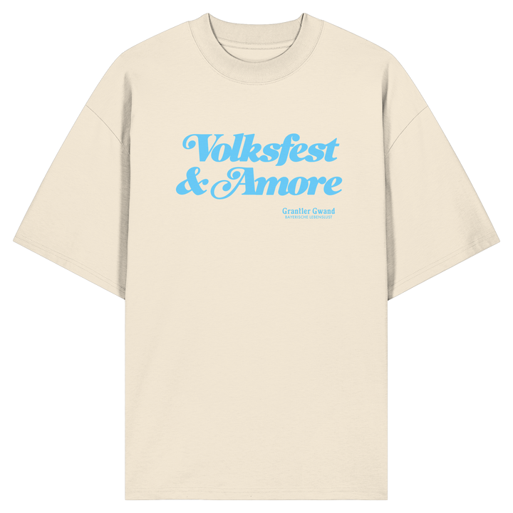 Beiges Oversize-T-Shirt mit blauem Frontprint „Volksfest &amp; Amore“. Modernes bayerisches Streetwear-Design für Volksfest, Biergarten und Freizeit. Hochwertiges Unisex Oversize-Shirt aus Bio-Baumwolle, designed und bedruckt in Bayern von Grantler Gwand.