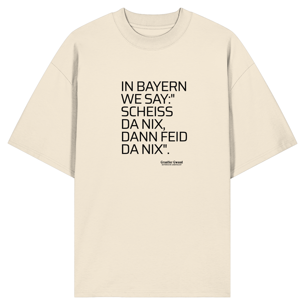 Naturfarbenes Oversize Shirt mit schwarzem Schriftzug "In Bayern we say: Scheiß da nix, dann feid da nix" im minimalistischen bayerischen Streetwear-Design von Grantler Gwand.