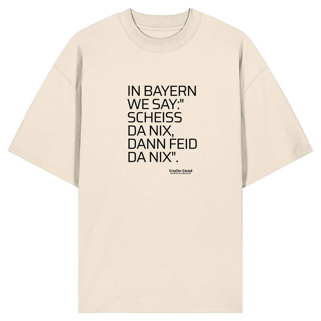 Naturfarbenes Oversize Shirt mit schwarzem Schriftzug "In Bayern we say: Scheiß da nix, dann feid da nix" im minimalistischen bayerischen Streetwear-Design von Grantler Gwand.