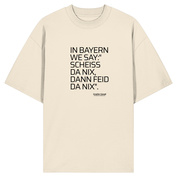 Naturfarbenes Oversize Shirt mit schwarzem Schriftzug "In Bayern we say: Scheiß da nix, dann feid da nix" im minimalistischen bayerischen Streetwear-Design von Grantler Gwand.