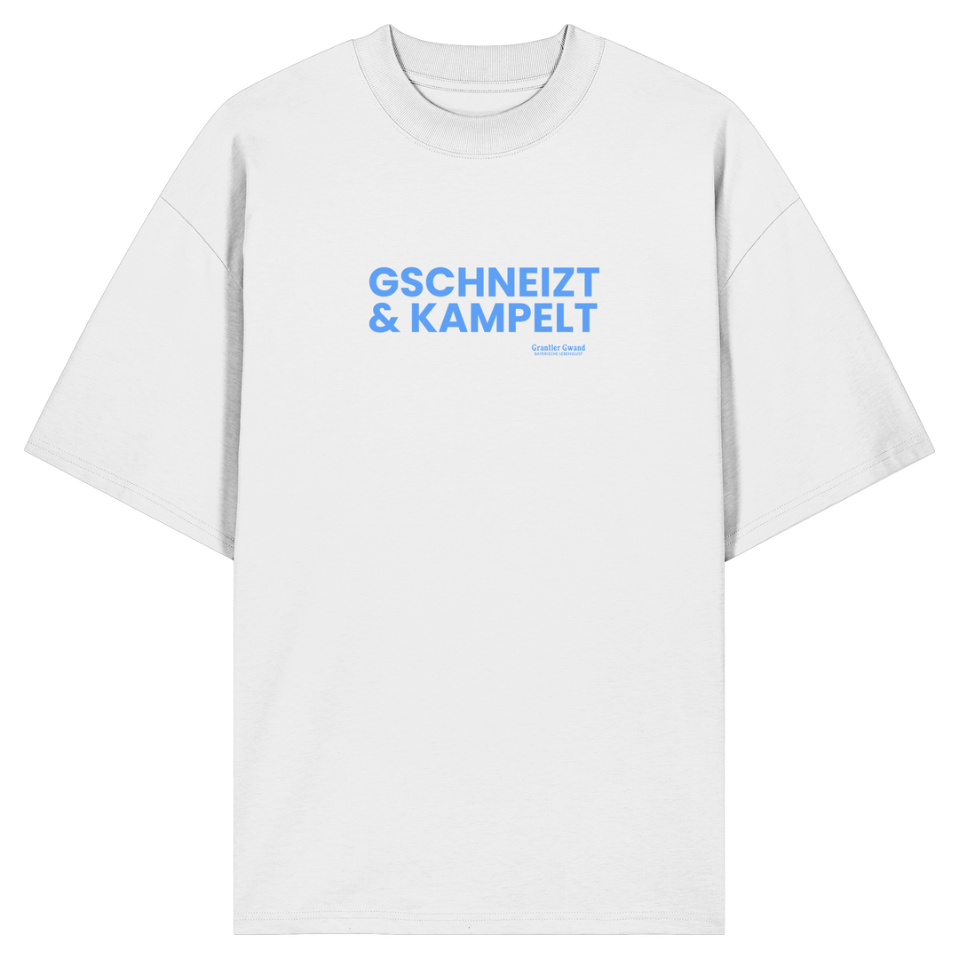 Weißes Oversize-T-Shirt mit blauem Frontprint „Gschneizt &amp; Kampelt“. Modernes bayerisches Streetwear-Shirt mit Dialekt-Motiv für Volksfest, Biergarten und Alltag. Hochwertige Bio-Baumwolle, designed und bedruckt in Bayern von Grantler Gwand.