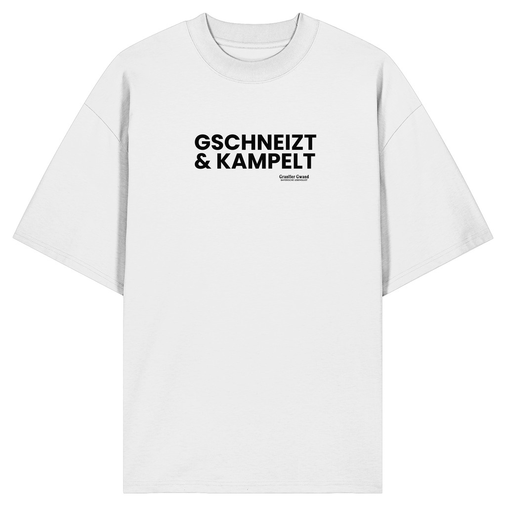 Weißes Oversize-T-Shirt mit schwarzem Frontprint „Gschneizt & Kampelt“. Modernes Unisex-Shirt mit bayerischem Dialekt im minimalistischen Streetwear-Design für Volksfest, Biergarten und Alltag. Hochwertige Bio-Baumwolle, designed und bedruckt in Bayern von Grantler Gwand.
