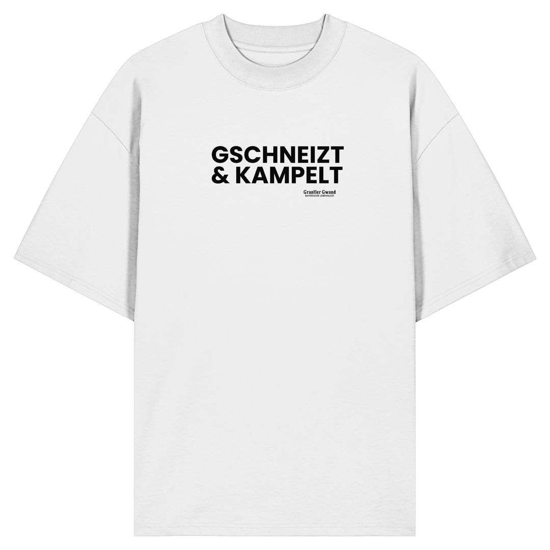 Weißes Oversize-T-Shirt mit schwarzem Frontprint „Gschneizt &amp; Kampelt“. Modernes Unisex-Shirt mit bayerischem Dialekt im minimalistischen Streetwear-Design für Volksfest, Biergarten und Alltag. Hochwertige Bio-Baumwolle, designed und bedruckt in Bayern von Grantler Gwand.