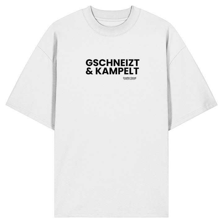 Weißes Oversize-T-Shirt mit schwarzem Frontprint „Gschneizt &amp; Kampelt“. Modernes Unisex-Shirt mit bayerischem Dialekt im minimalistischen Streetwear-Design für Volksfest, Biergarten und Alltag. Hochwertige Bio-Baumwolle, designed und bedruckt in Bayern von Grantler Gwand.