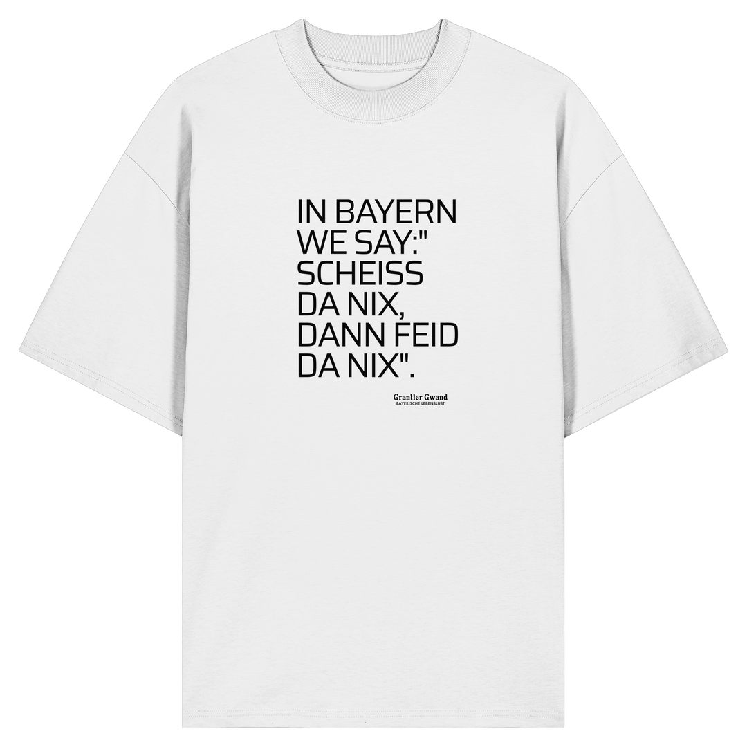 Weißes Oversize Shirt mit schwarzem Schriftzug "In Bayern we say: Scheiß da nix, dann feid da nix" im minimalistischen bayerischen Streetwear-Design von Grantler Gwand.