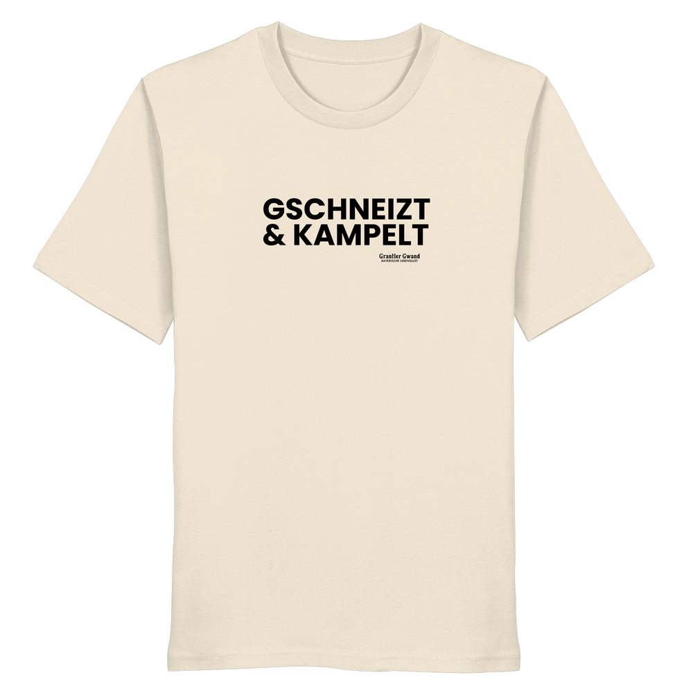 Beiges Unisex-T-Shirt mit schwarzem Frontprint „Gschneizt & Kampelt“. Modernes bayerisches Dialekt-Shirt im minimalistischen Streetwear-Design für Volksfest, Biergarten und Alltag. Hochwertige Baumwolle, designed und bedruckt in Bayern von Grantler Gwand.