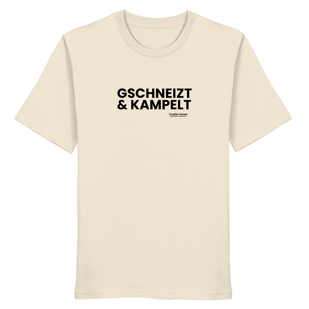Beiges Unisex-T-Shirt mit schwarzem Frontprint „Gschneizt &amp; Kampelt“. Modernes bayerisches Dialekt-Shirt im minimalistischen Streetwear-Design für Volksfest, Biergarten und Alltag. Hochwertige Baumwolle, designed und bedruckt in Bayern von Grantler Gwand.