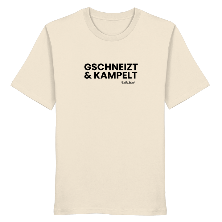 Beiges Unisex-T-Shirt mit schwarzem Frontprint „Gschneizt &amp; Kampelt“. Modernes bayerisches Dialekt-Shirt im minimalistischen Streetwear-Design für Volksfest, Biergarten und Alltag. Hochwertige Baumwolle, designed und bedruckt in Bayern von Grantler Gwand.