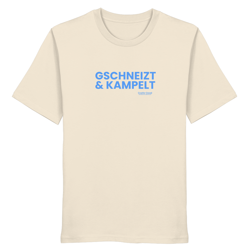 Beiges T-Shirt mit blauem Frontprint „Gschneizt & Kampelt“. Bayerisches Dialekt-Shirt im modernen Streetwear-Style für Volksfest, Biergarten und Alltag. Hochwertige Baumwolle, designed und bedruckt in Bayern von Grantler Gwand.