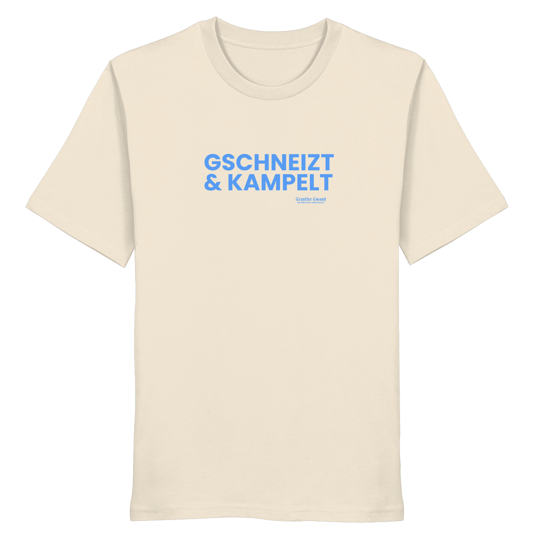Beiges T-Shirt mit blauem Frontprint „Gschneizt &amp; Kampelt“. Bayerisches Dialekt-Shirt im modernen Streetwear-Style für Volksfest, Biergarten und Alltag. Hochwertige Baumwolle, designed und bedruckt in Bayern von Grantler Gwand.