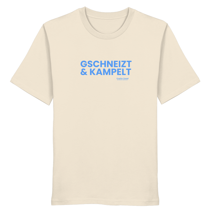 Beiges T-Shirt mit blauem Frontprint „Gschneizt &amp; Kampelt“. Bayerisches Dialekt-Shirt im modernen Streetwear-Style für Volksfest, Biergarten und Alltag. Hochwertige Baumwolle, designed und bedruckt in Bayern von Grantler Gwand.