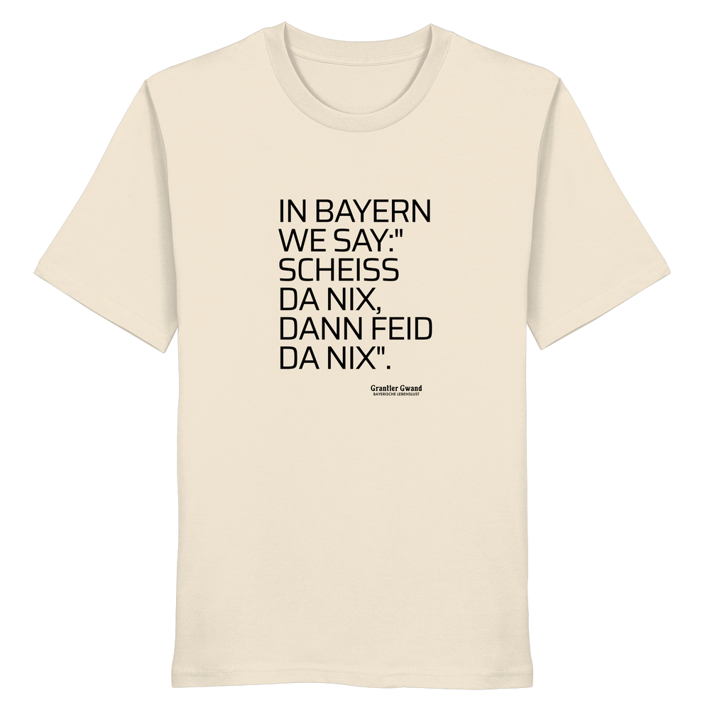 Naturfarbenes Shirt mit schwarzem Schriftzug "In Bayern we say: Scheiß da nix, dann feid da nix" im minimalistischen bayerischen Streetwear-Design von Grantler Gwand.