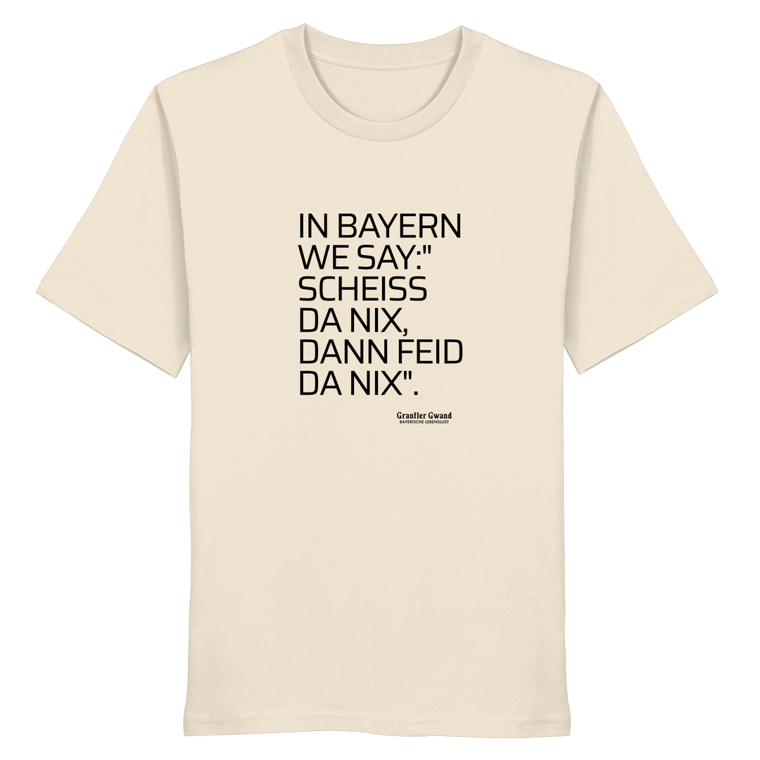 Naturfarbenes Shirt mit schwarzem Schriftzug "In Bayern we say: Scheiß da nix, dann feid da nix" im minimalistischen bayerischen Streetwear-Design von Grantler Gwand.